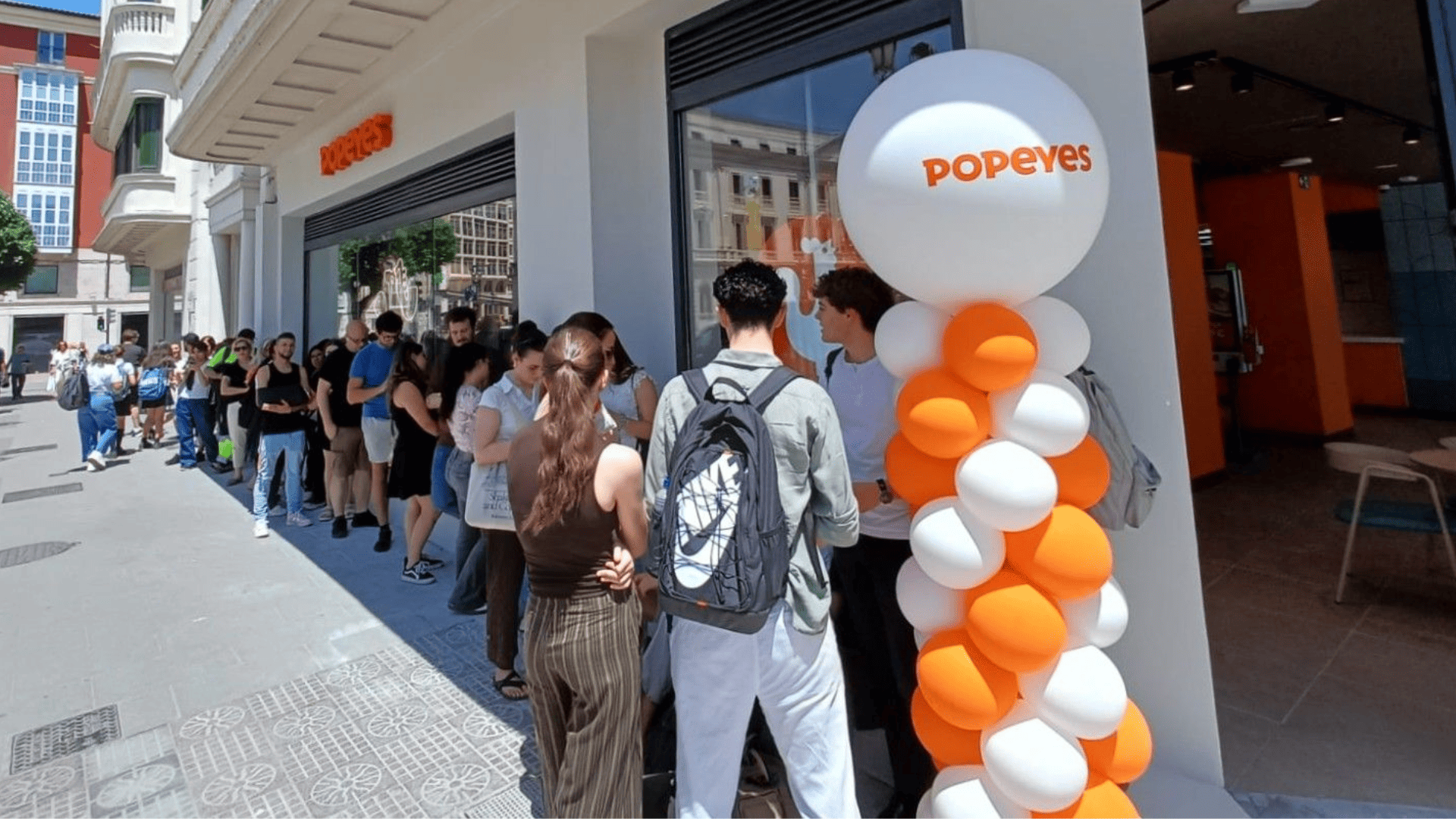 larga cola frente a popeyes con globos
