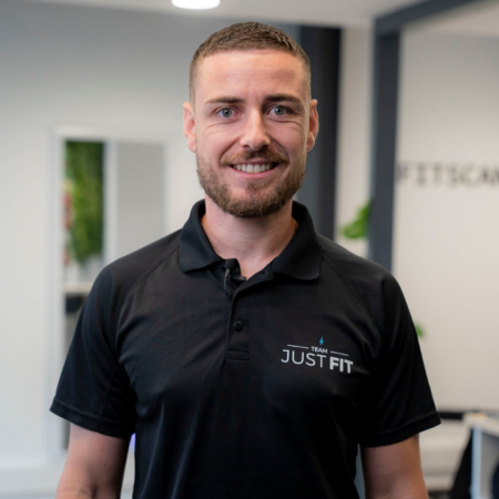 coach just fit souriant en studio de fitness