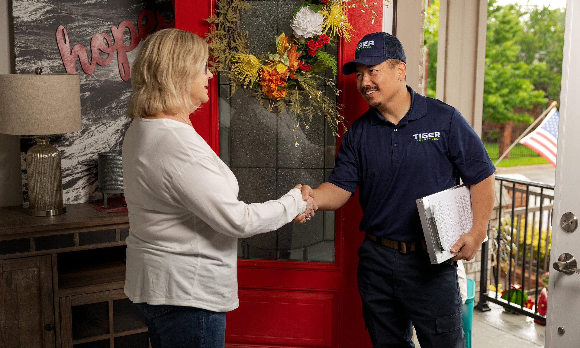 homeowner greets service technician at red door