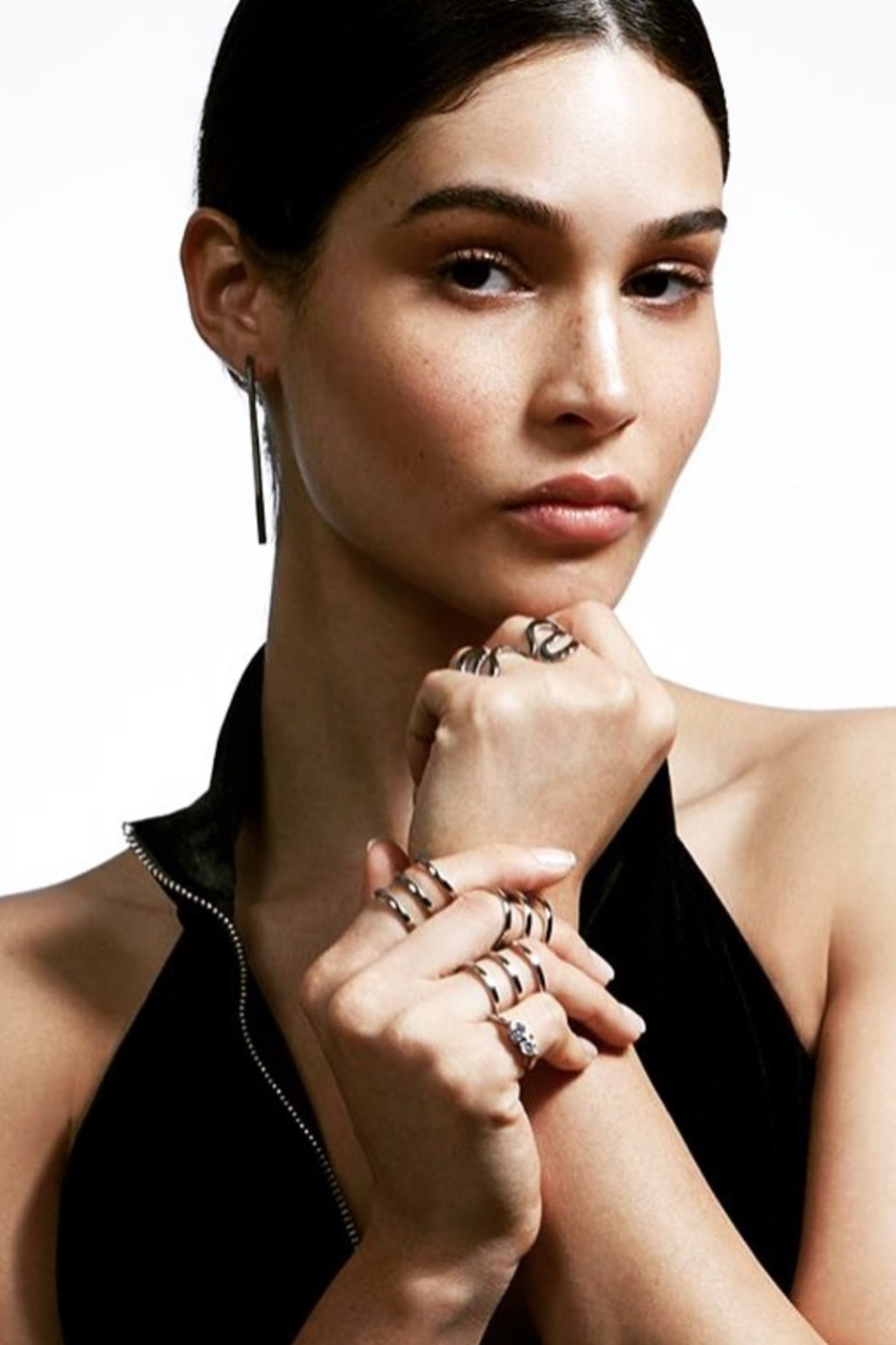 retrato minimalista de mujer con joyas y manos elegantes