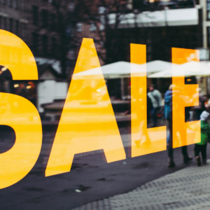 orange sale window reflecting city street scene