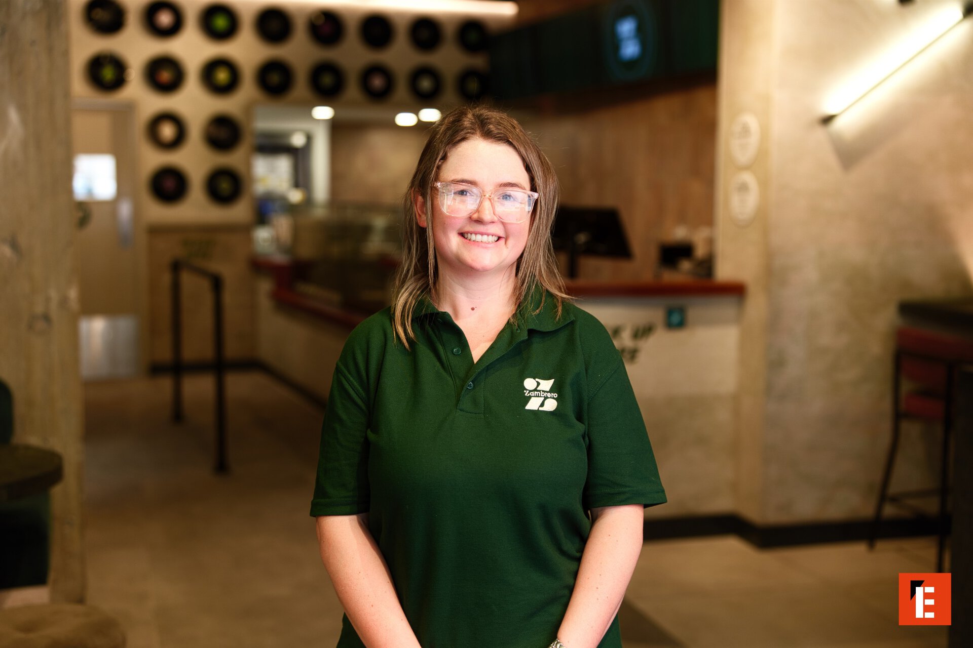 smiling restaurant staff portrait in green polo