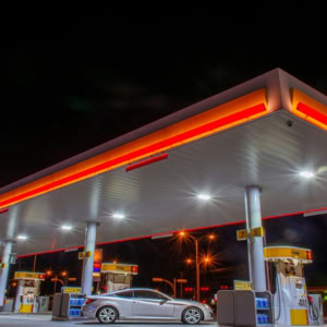 station service de nuit au néon avec voiture