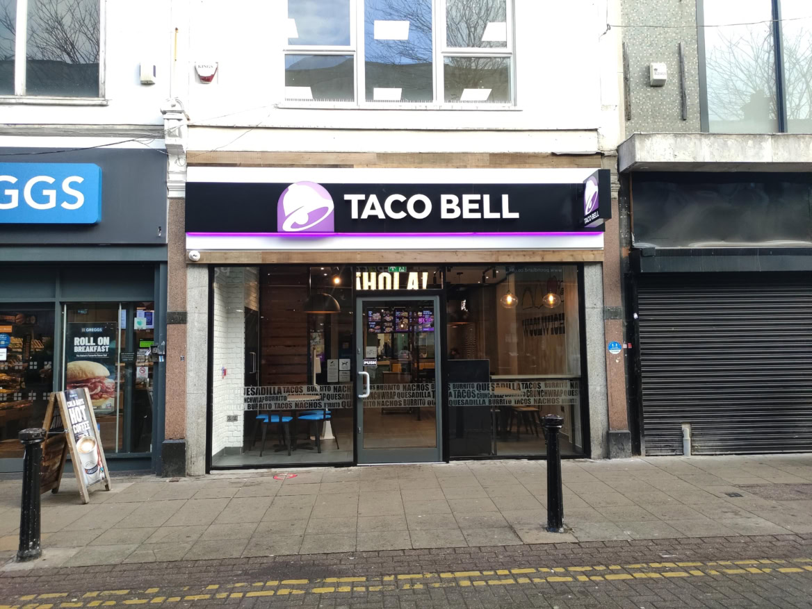 taco bell in einkaufsstraße mit leuchtender glasfassade