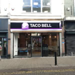taco bell in einkaufsstraße mit leuchtender glasfassade