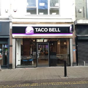 taco bell in einkaufsstraße mit leuchtender glasfassade