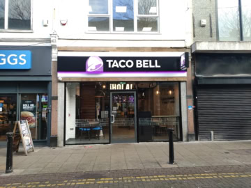taco bell in einkaufsstraße mit leuchtender glasfassade