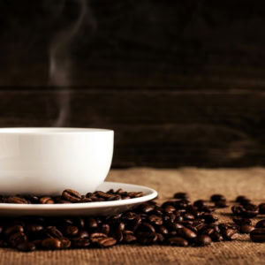 tasse de café fumant et grains torréfiés
