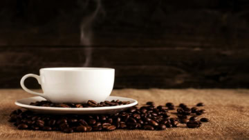 tasse de café fumant et grains torréfiés