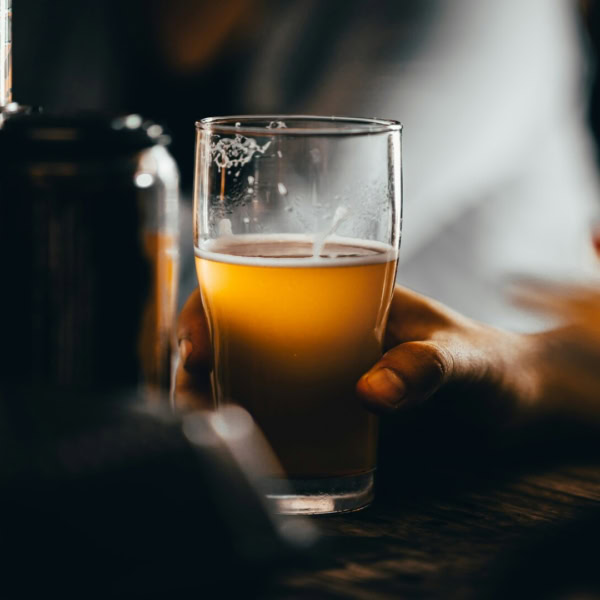 verre de bière non filtrée tenu à la main