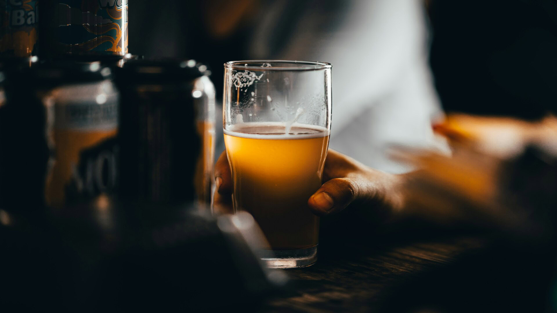 verre de bière non filtrée tenu à la main