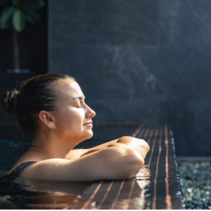 sunlit woman resting at indoor pool