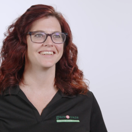 smiling redhead professional headshot in branded polo