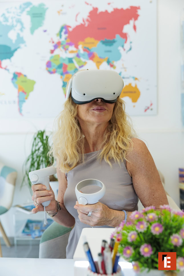 donna con visore vr e controller in casa