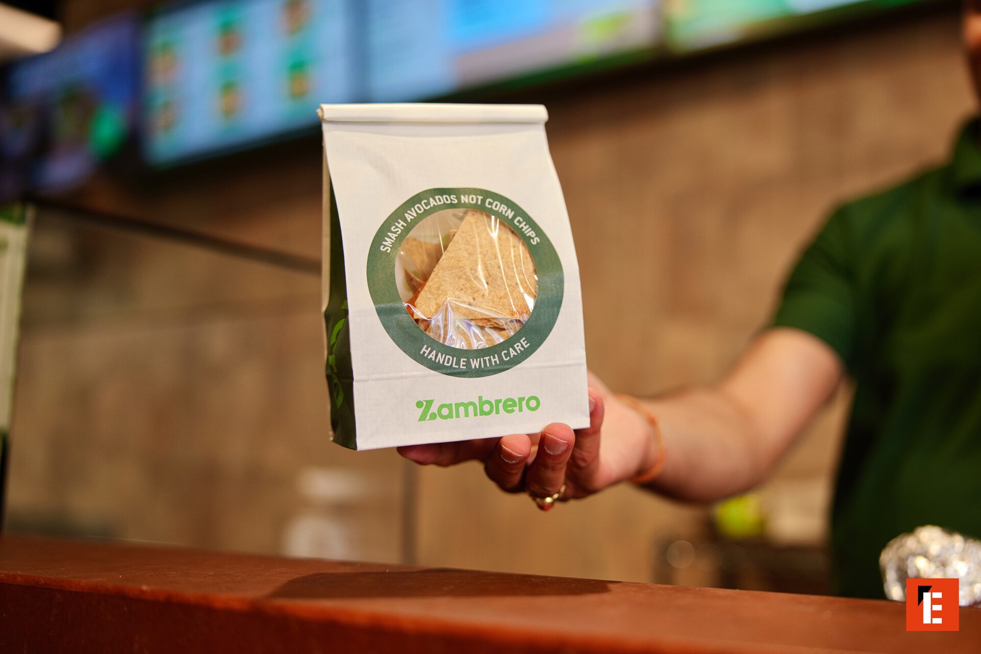 zambrero staff offering corn chip packet
