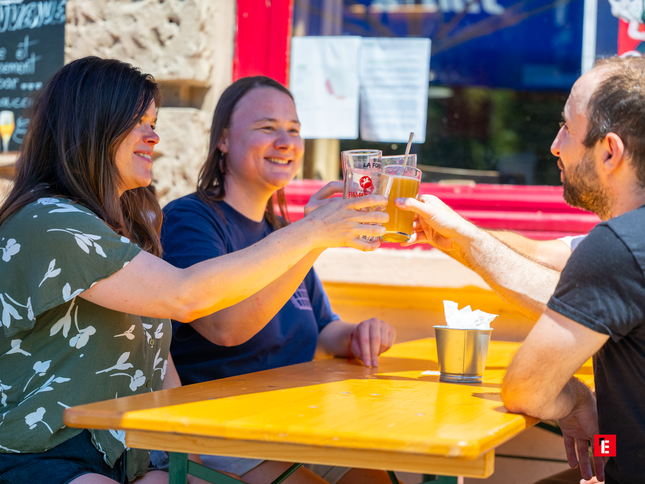 amis trinquant À la bière sur la terrasse ensoleillée