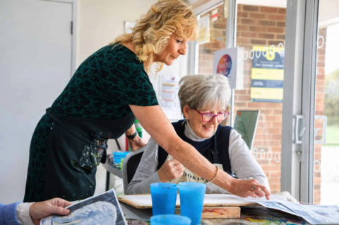 sunlit art workshop: tutor guiding senior student