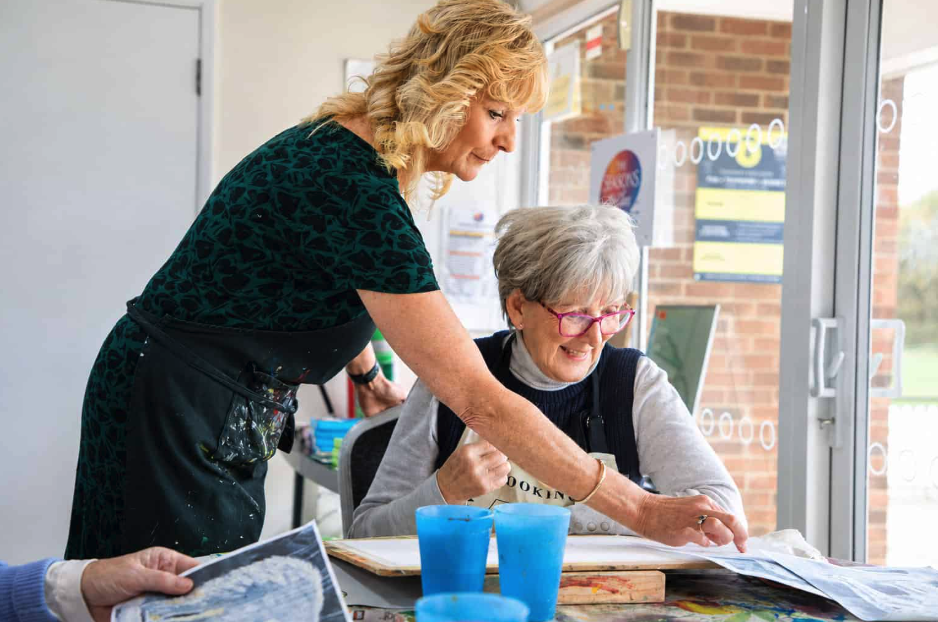 sunlit art workshop: tutor guiding senior student