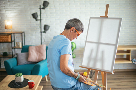 artist mixing yellow paint in cosy home studio