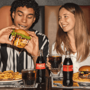 coppia al ristorante: hamburger, patatine e coca cola