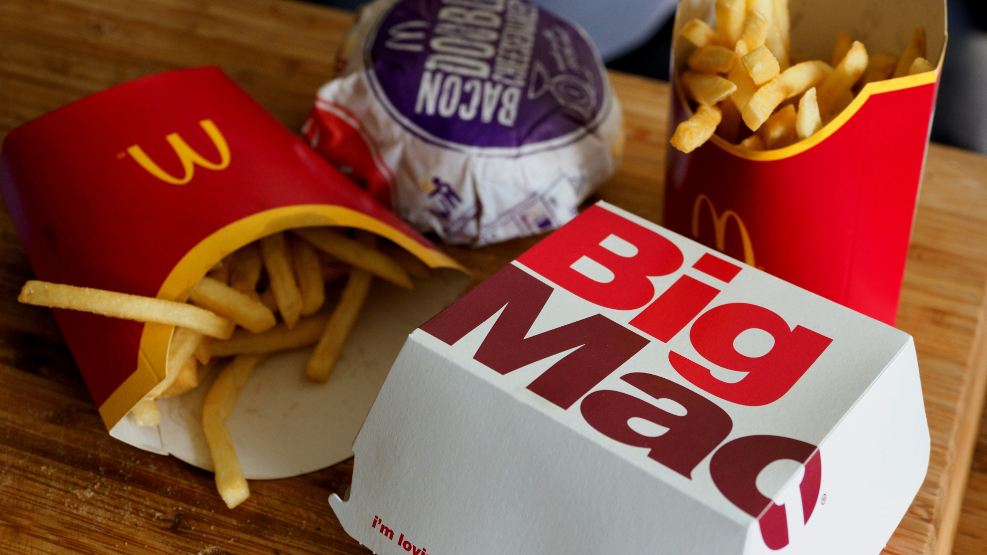 mcdonalds big mac mit pommes auf holztisch