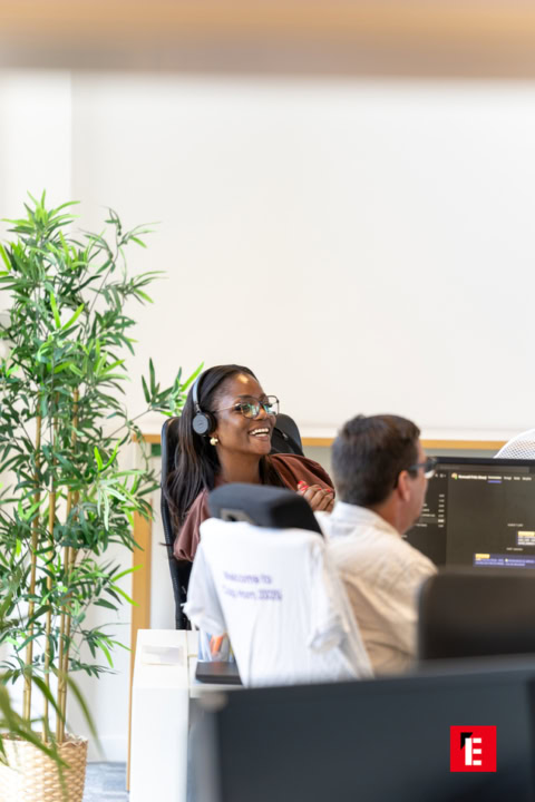 employée souriante avec casque dans bureau moderne