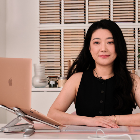 femme au bureau organisé avec ordinateur rose doré et micro
