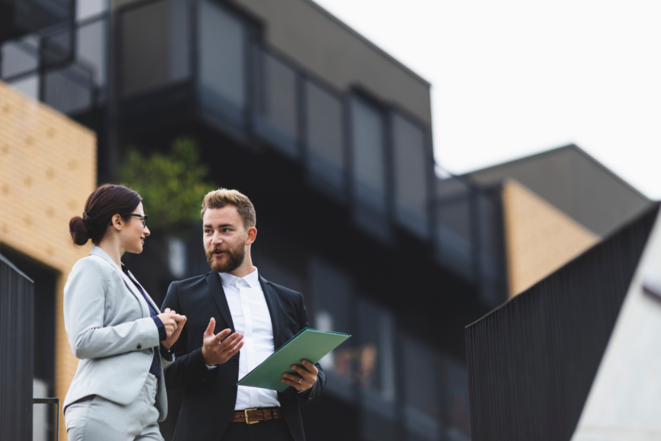 conversation professionnelle devant un immeuble moderne