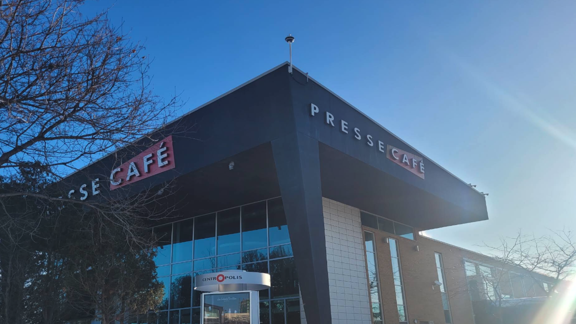 façade moderne de presse café centropolis au ciel bleu
