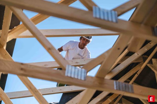 ouvrier sous charpente bois vue den bas