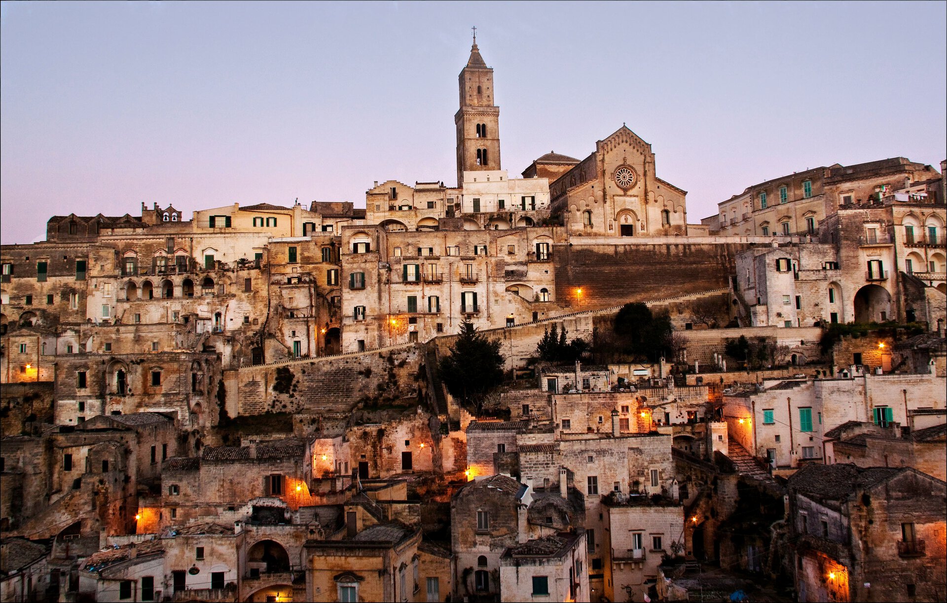 borgo in pietra al tramonto con campanile illuminato