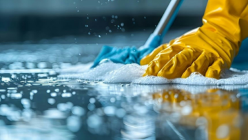 yellow glove scrubbing soapy reflective floor
