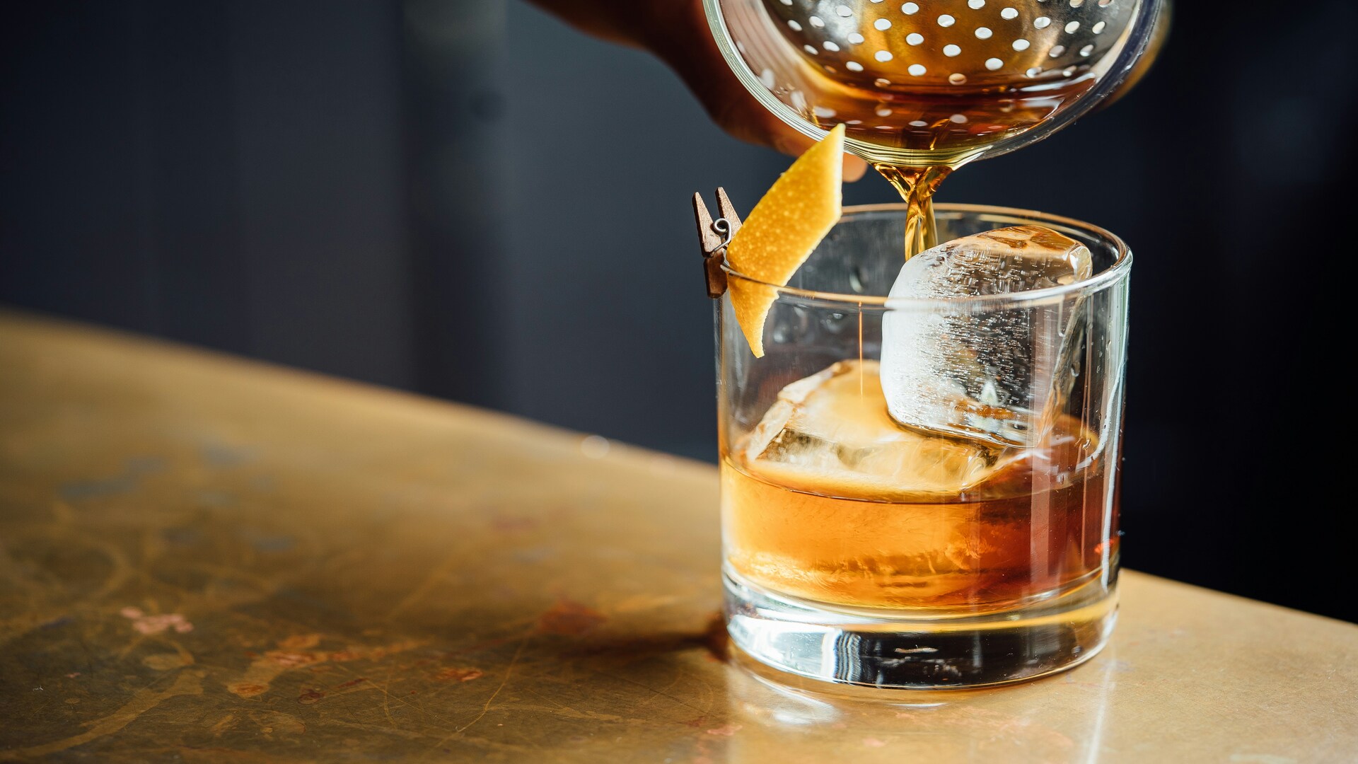 cocktail ambré au glaçon carré et zeste