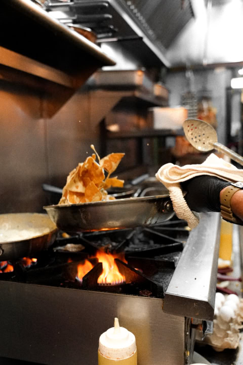 chef saisissant une poêle au feu de cuisine