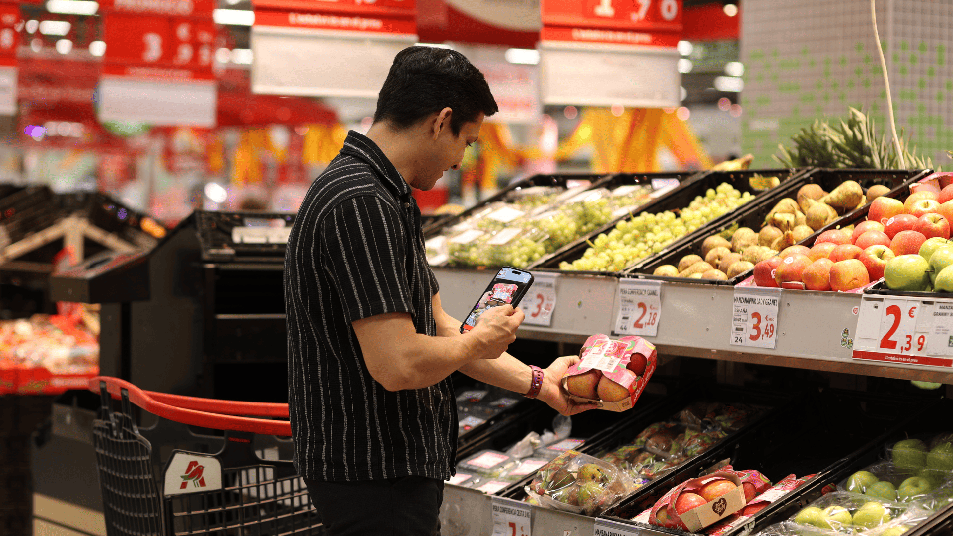 comprador escanea manzanas con móvil en supermercado