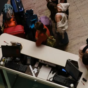 voyageurs au comptoir denregistrement avec valises colorées