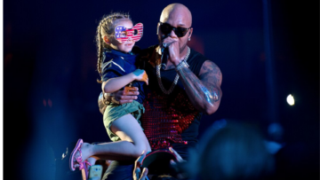 singer lifts young fan under blue stage lights