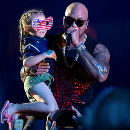 singer lifts young fan under blue stage lights