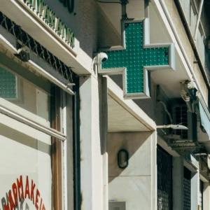 insegna croce verde su facciata cittadina
