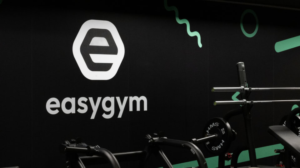 logo easygym na nowoczesnej siłowni ze sztangą