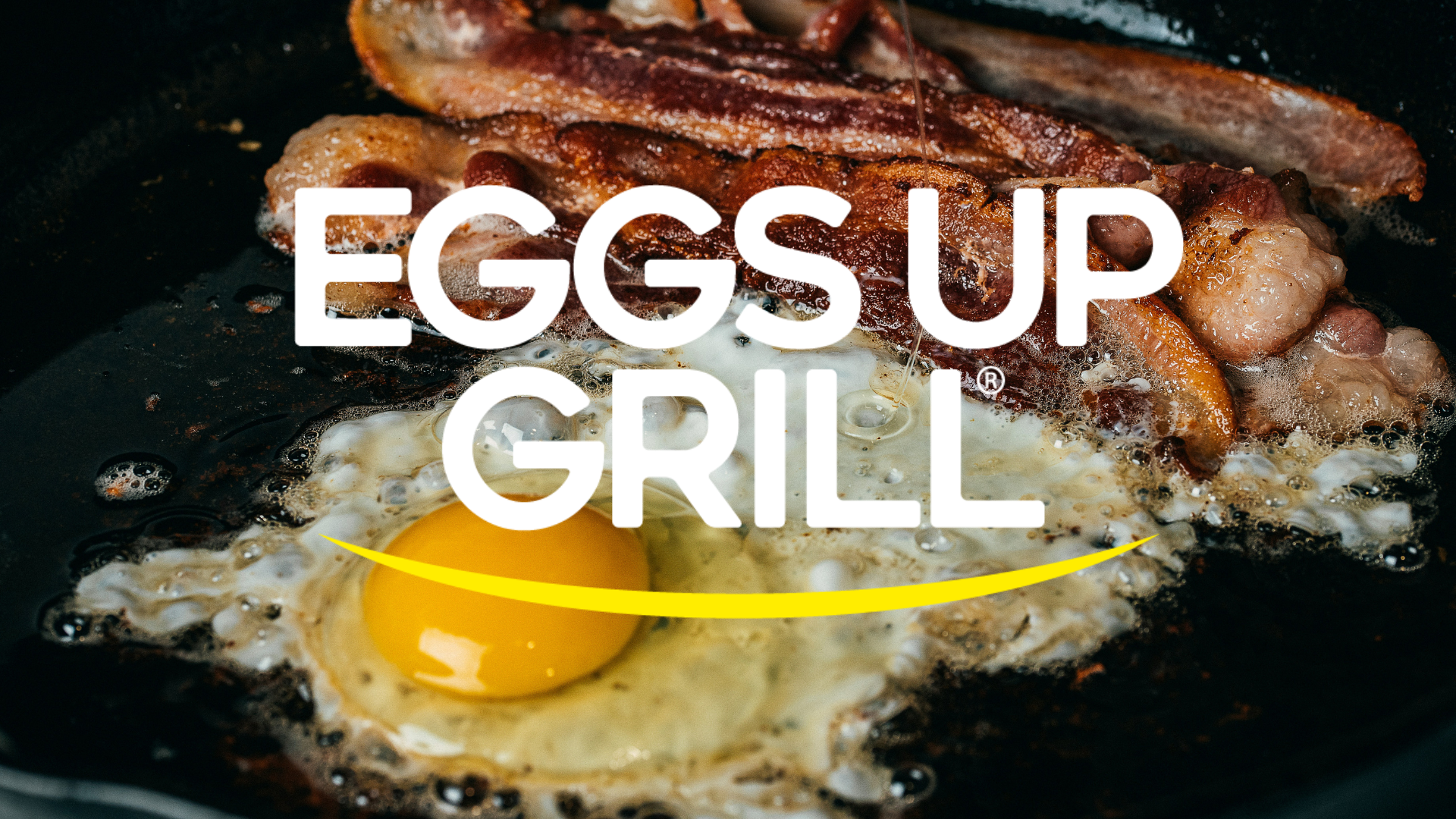 sizzling egg with runny yolk and crispy bacon