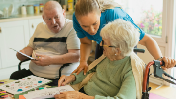 senior woman and caregiver coloring together
