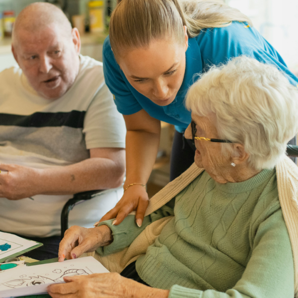 senior woman and caregiver coloring together