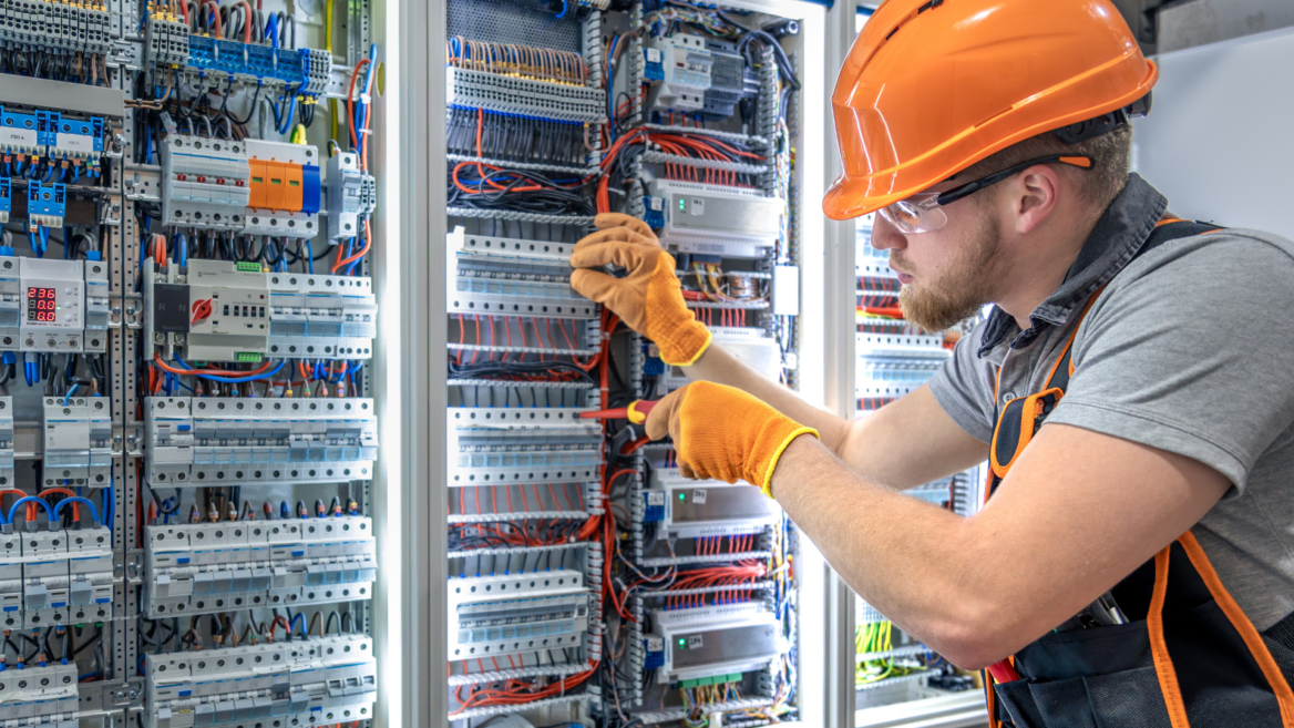 elektriker prüft schaltschrank mit kabeln und sicherungen