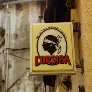 enseigne café corsica: profil bandana noir sur façade