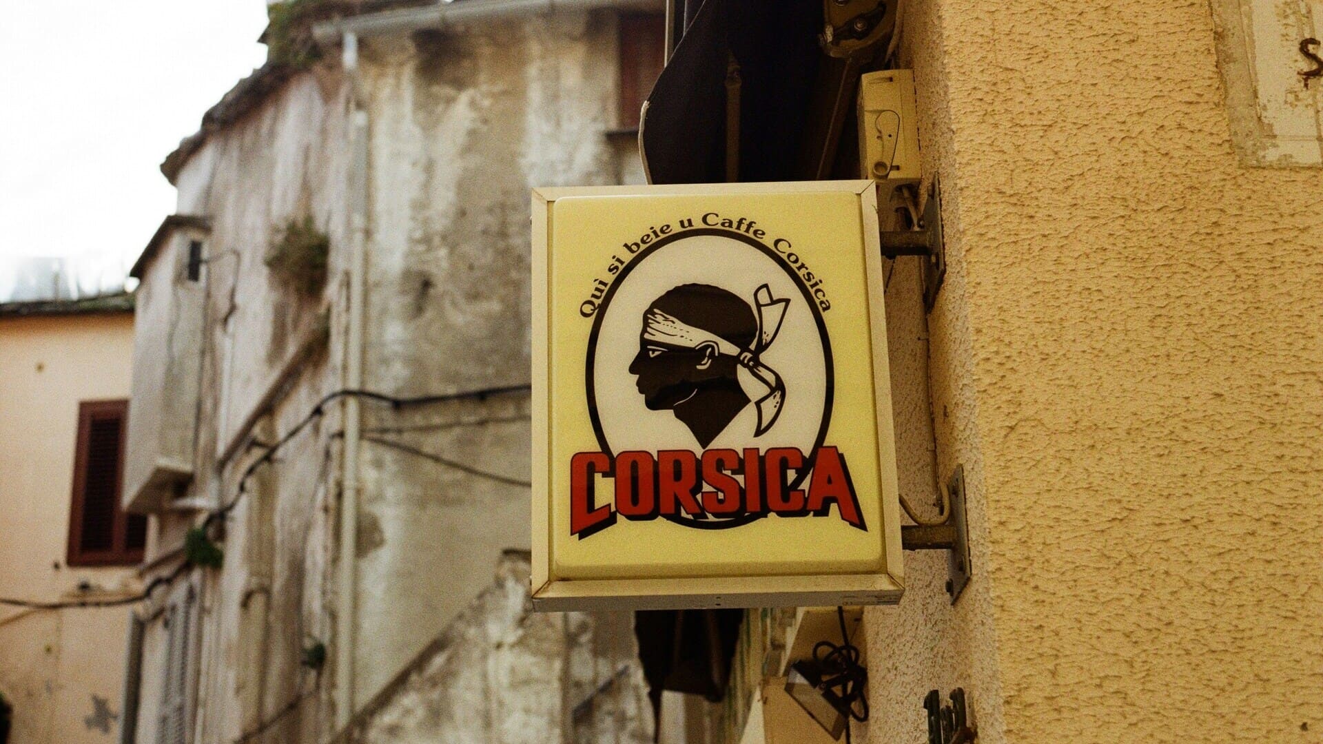 enseigne café corsica: profil bandana noir sur façade