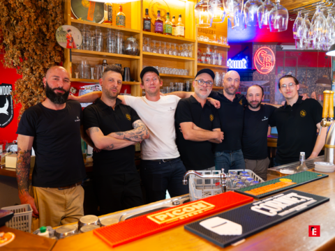 sept barmans souriants au comptoir du pub