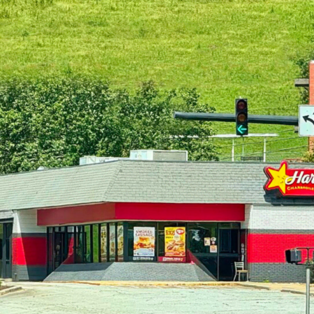 red hardees restaurant at sunny suburban intersection