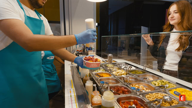 serveuse de salade au comptoir, cliente souriante