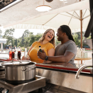 lachendes paar am sonnigen foodtruck im park